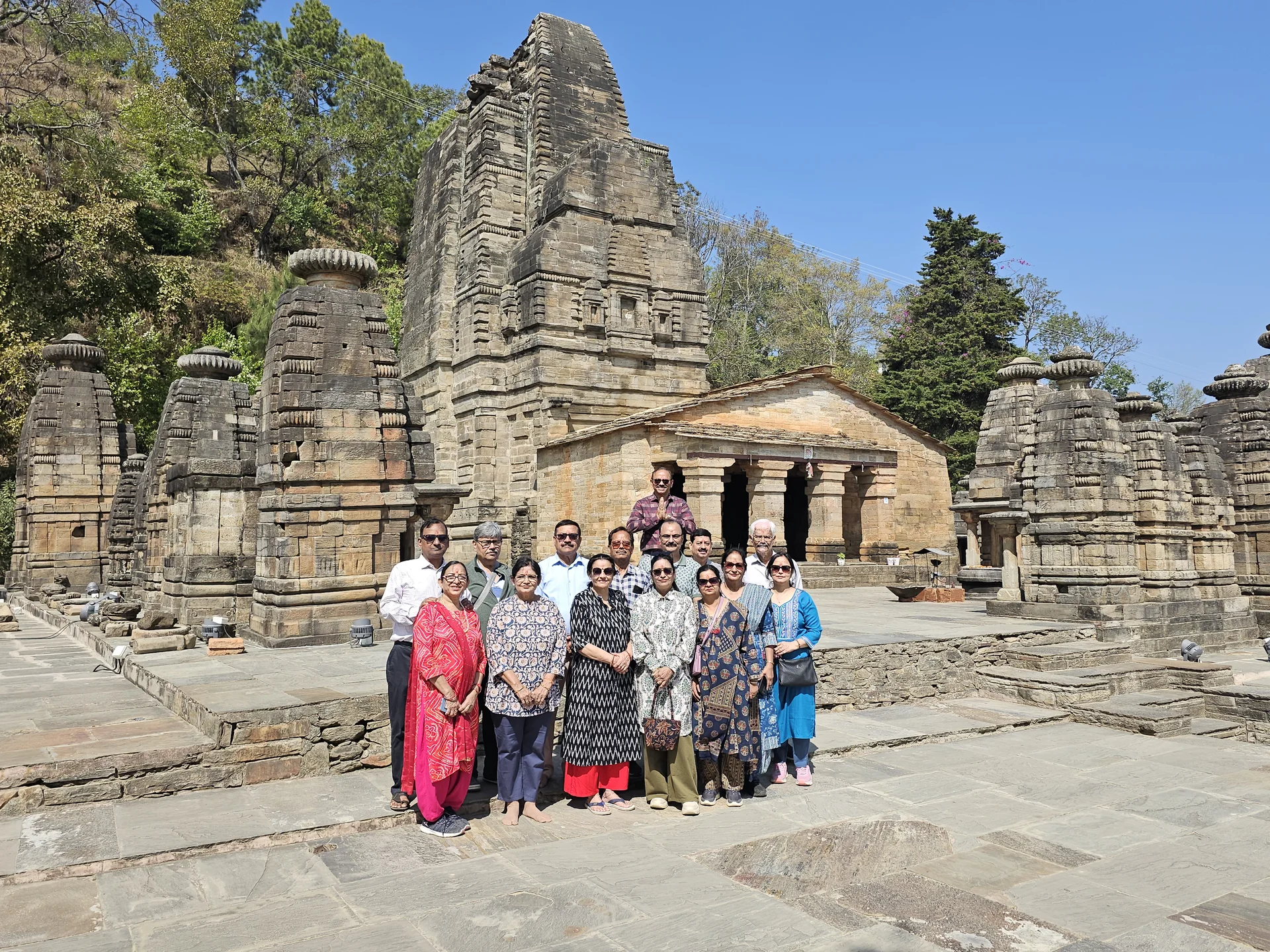 Devotee family gathered before the 8th-century stone temples of Jageshwar Dham