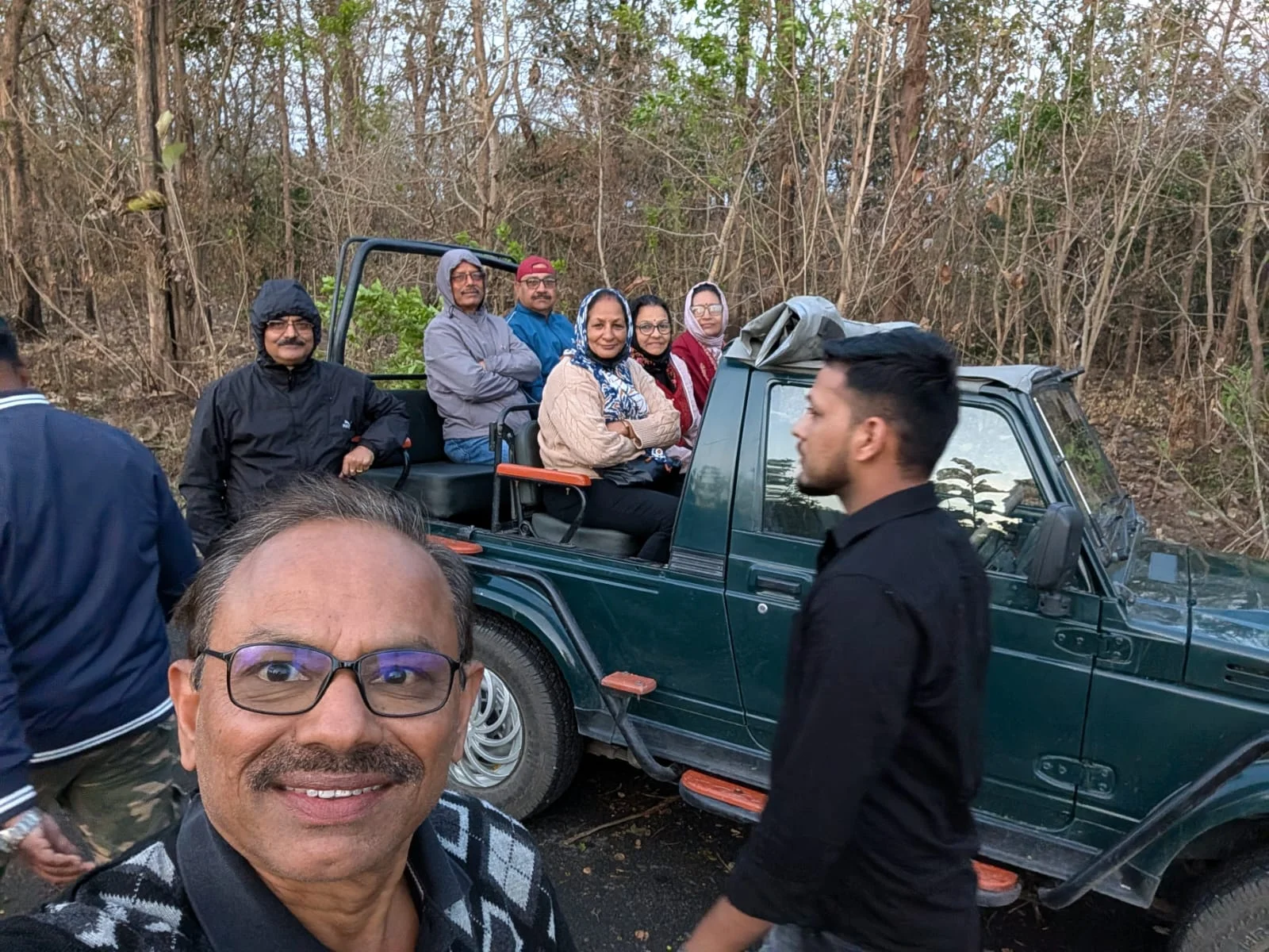 Tourists and pilgrims enjoying jungle safari inside 4x4 open Gypsy with professional driver