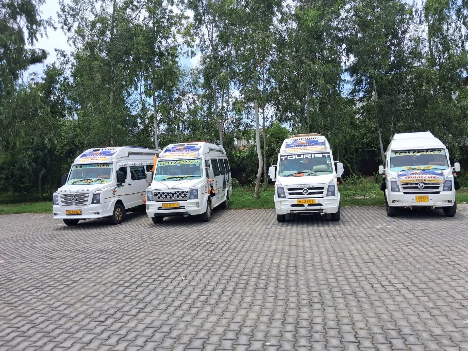 Four pristine white Force Travellers lined up with yellow commercial mountain plates